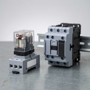 Qué es un contactor, para qué sirve y cómo elegirlo 5 comparación de tamaño entre un relé de control enchufable y un contactor trifásico sobre una mesa de trabajo. 1